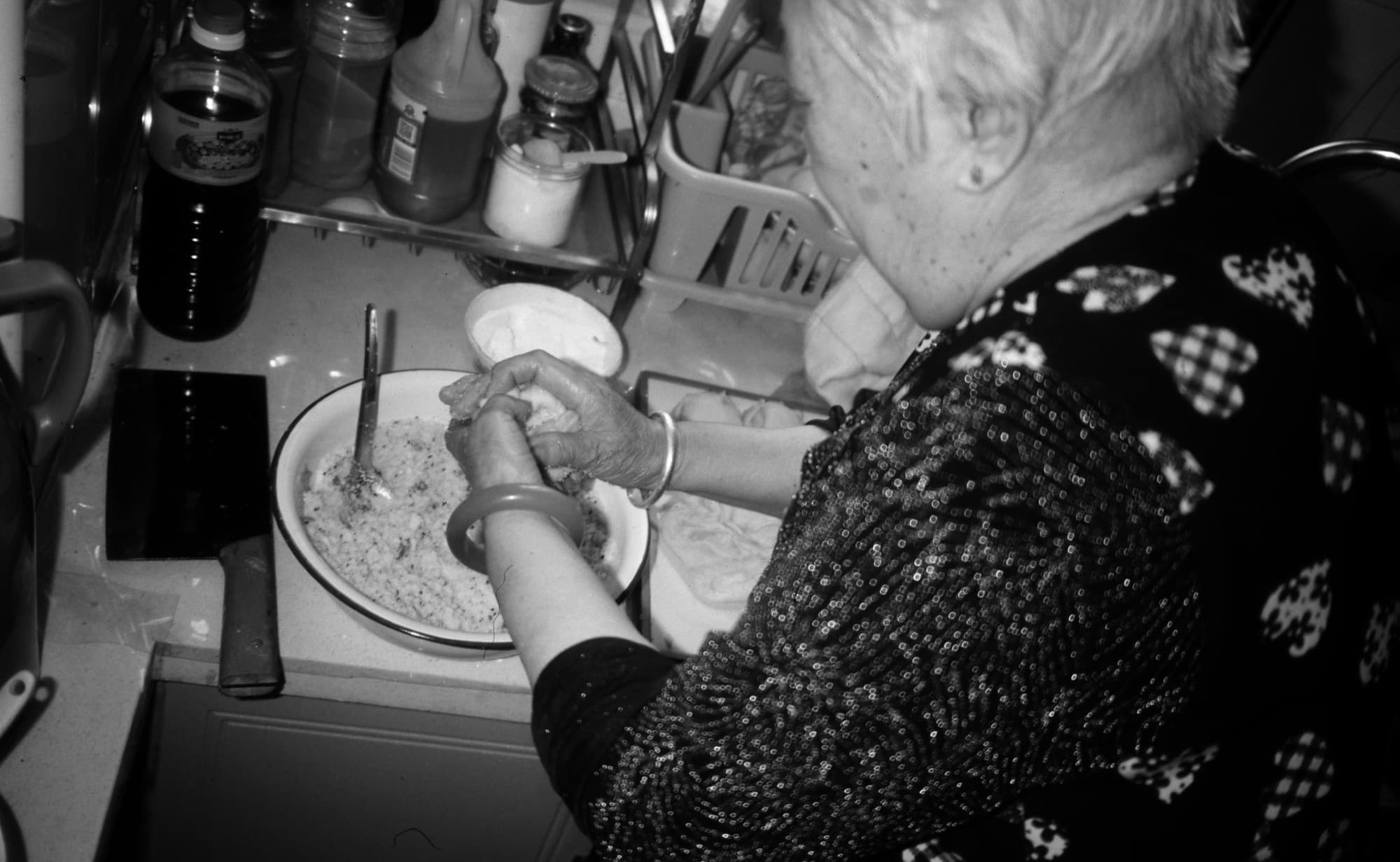 A grandmother shaping dough by hand in her kitchen